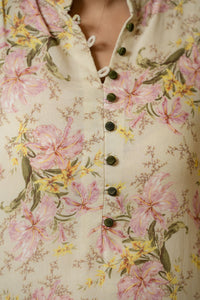 Close-up of antique gold snap buttons and ruffled mandarin collar detail