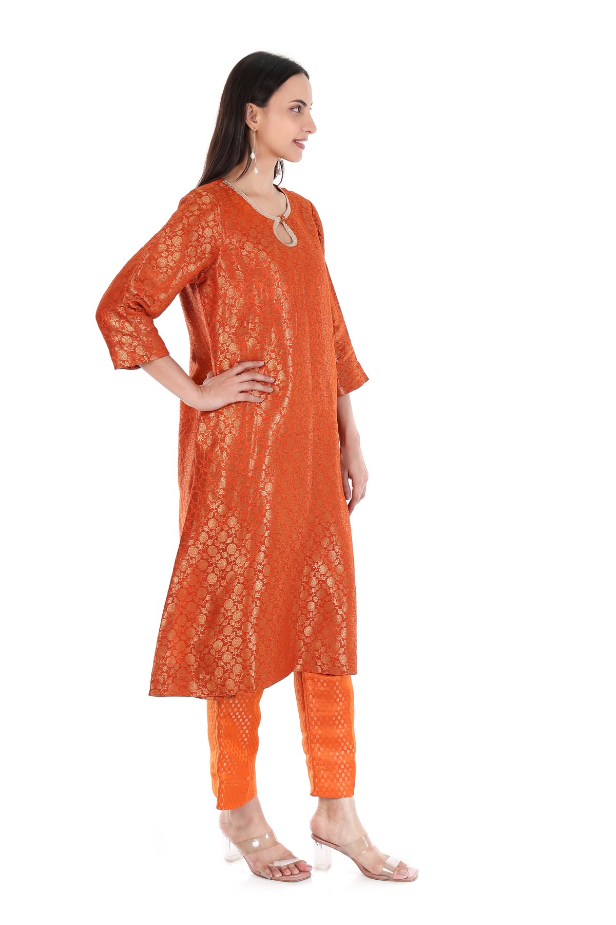 Side view of burnt orange kurta and trouser set showing side slit and gold-tone floral motifs