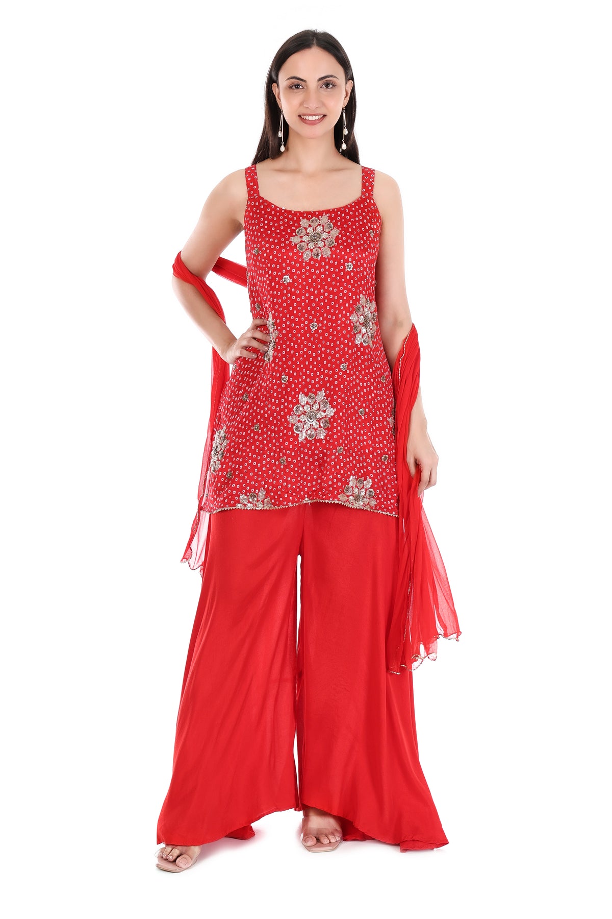 Close-up of metallic floral embellishments and contrasting ring motifs on red kurta