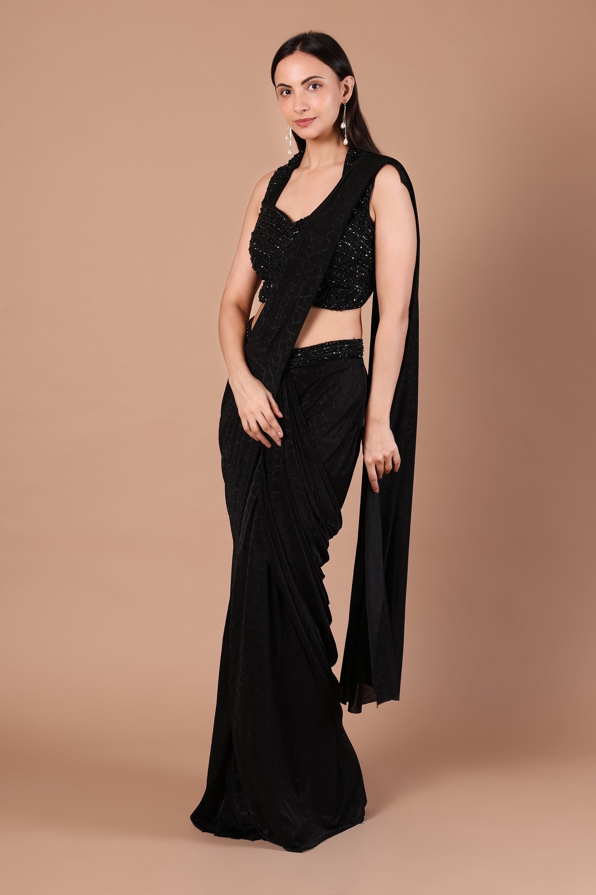 Midnight black saree showing flowing folds and long shoulder-draped pallu