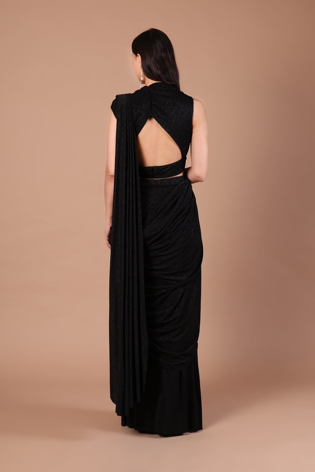 Back view of black saree and blouse showing large geometric back cut-out